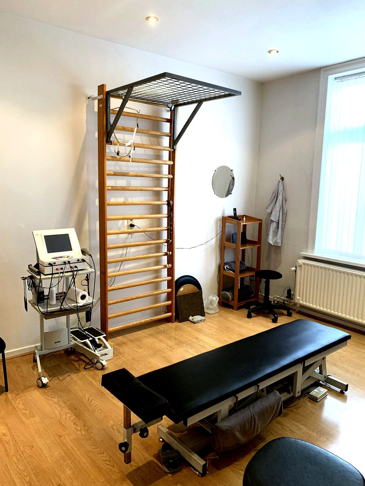 Vue d'ensemble du cabinet de kinésithérapie à Uccle : table de traitement et espace de rééducation fonctionnelle